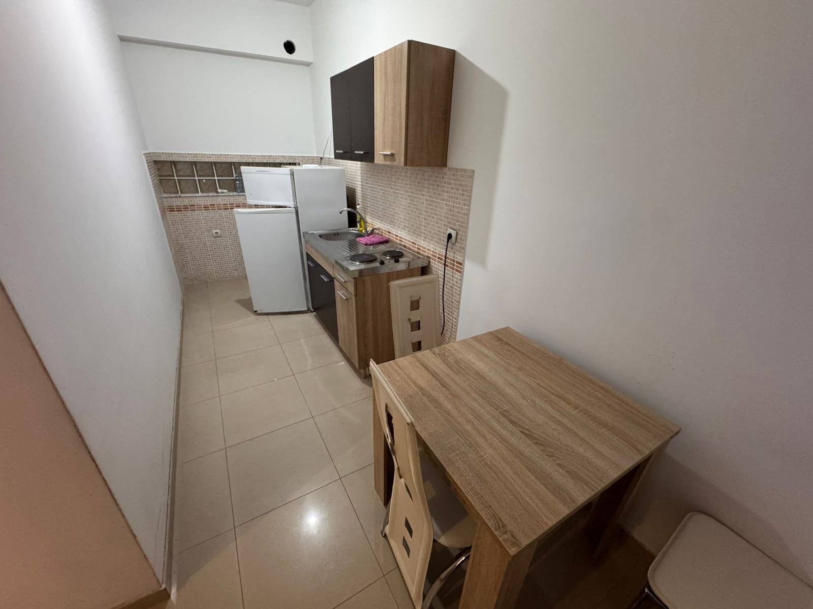 Bright, well-equipped Ulcinj kitchen with light wood cabinetry, modern appliances, and dining area&mdash;perfect real estate investment. Montenegro-listings.me by ekosphere doo.