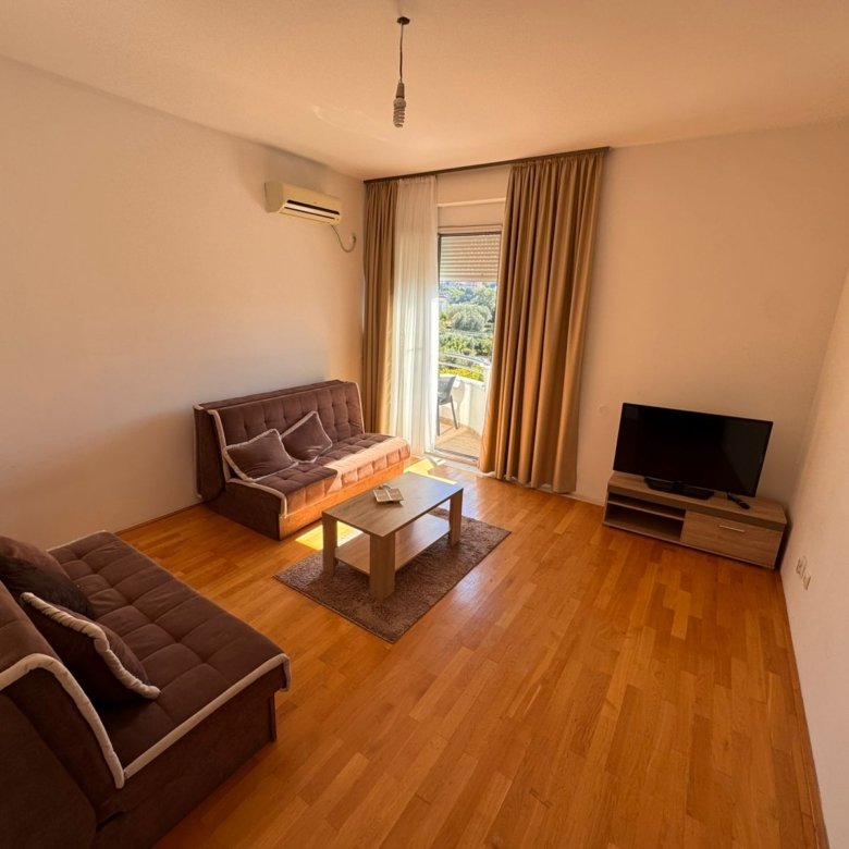 Elegant Ulcinj living room: wooden floors, brown sofas, AC, TV, and modern d&eacute;cor&mdash;exclusive at immorenta.me by ekosphere doo.