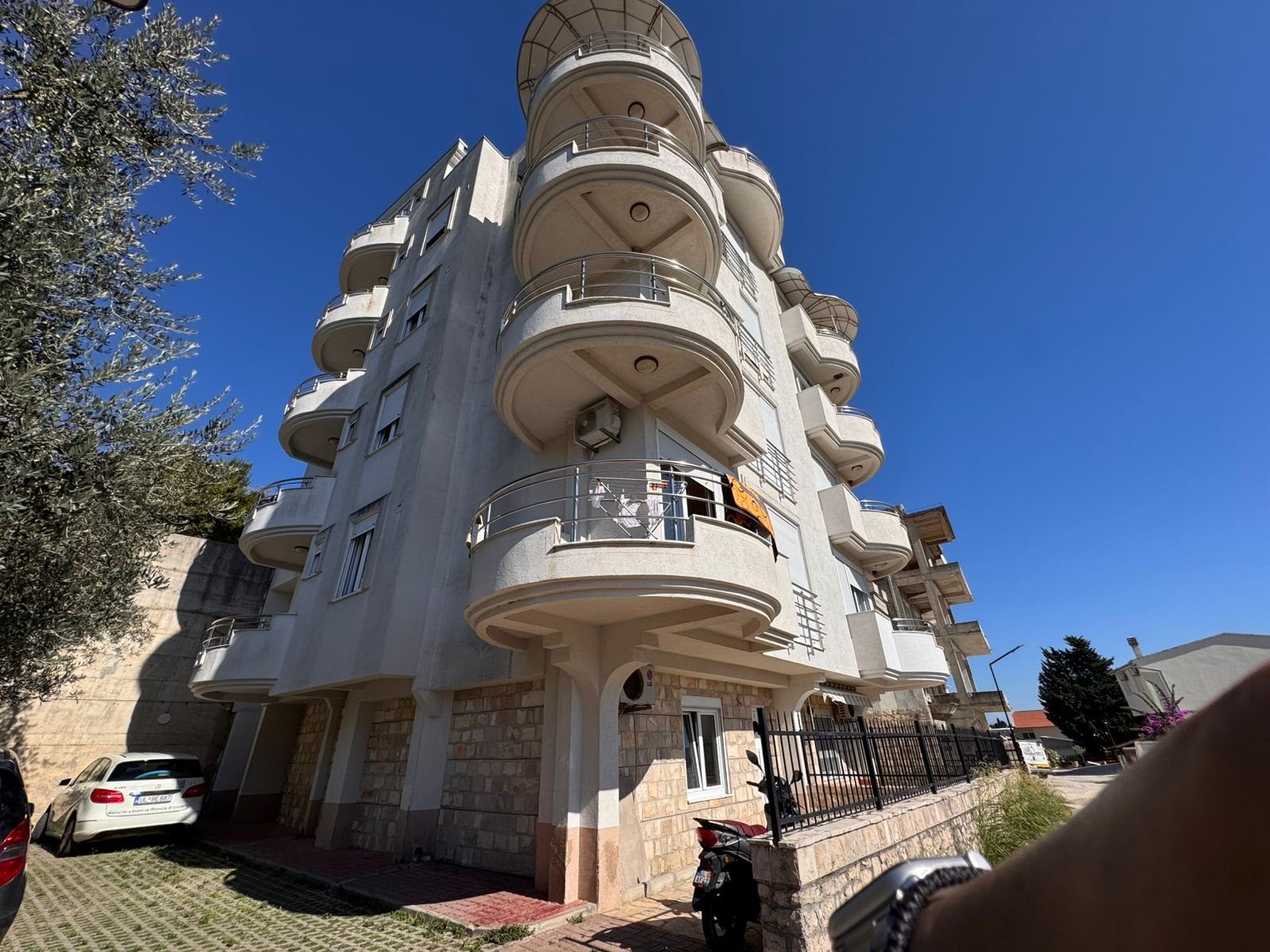 Modern multi-story residence in Ulcinj, Montenegro: curved balconies, white facade, parking. Exclusive on immorenta.me by ekosphere doo.