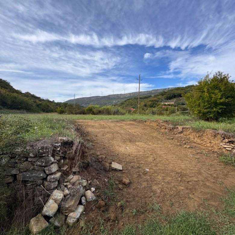 Scenic Ulcinj land for sale: serene grassy terrain, green hills, wind turbines, and investment potential from ekosphere doo.