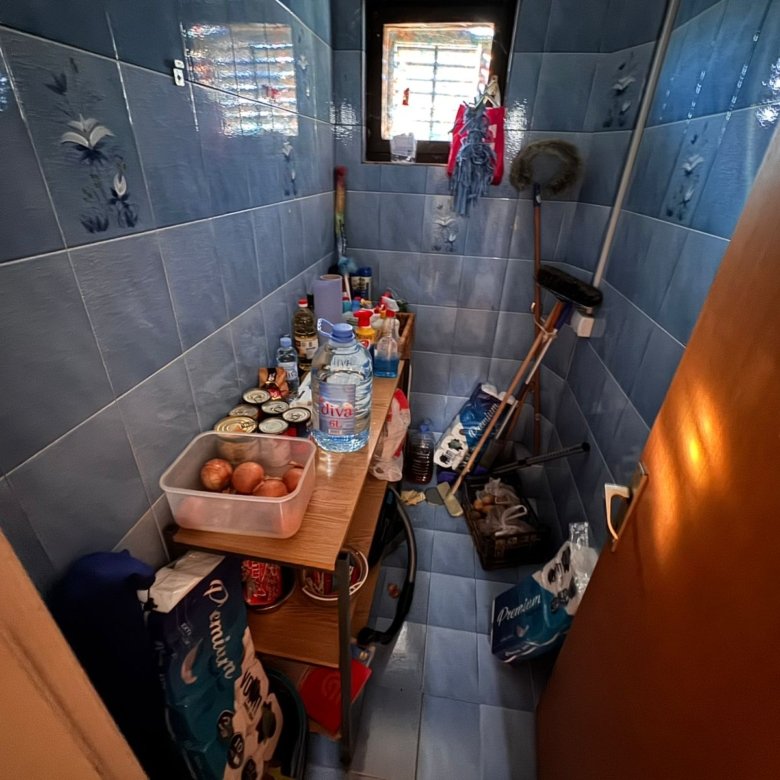 Efficient Ulcinj pantry with blue tiled walls, ample shelving, natural light&mdash;ideal Montenegro property feature. Montenegro-listings.me by ekosphere doo.