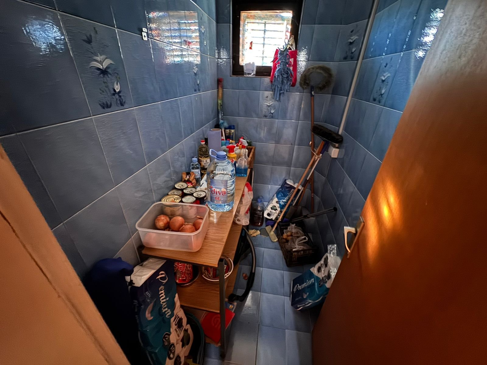 Efficient Ulcinj pantry with blue tiled walls, ample shelving, natural light&mdash;ideal Montenegro property feature. Montenegro-listings.me by ekosphere doo.