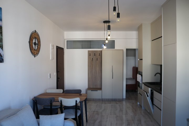 Stylish Ulcinj studio apartment with dining area, modern kitchen, cozy sofa, alcove bed. Invest in Montenegro at immorenta.me by ekosphere doo.