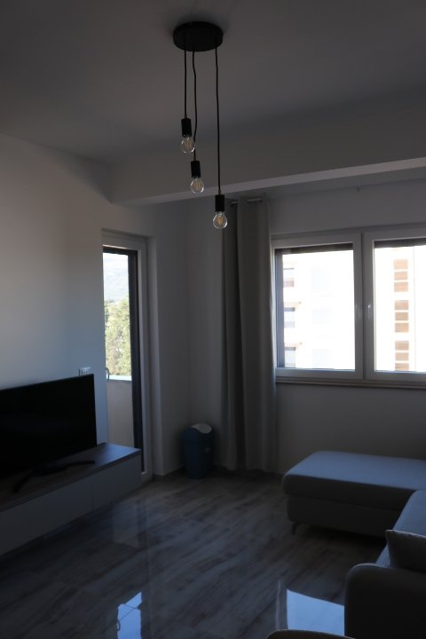 Stylish, modern Ulcinj living room with large windows, gray sectional, and chic lighting&mdash;top property at immorenta.me by ekosphere doo.