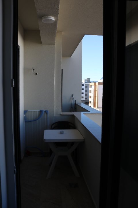 Charming Ulcinj balcony with white table, chair, and drying rack. Enjoy blue sky views&mdash;exclusive listing by ekosphere doo on immorenta.me.