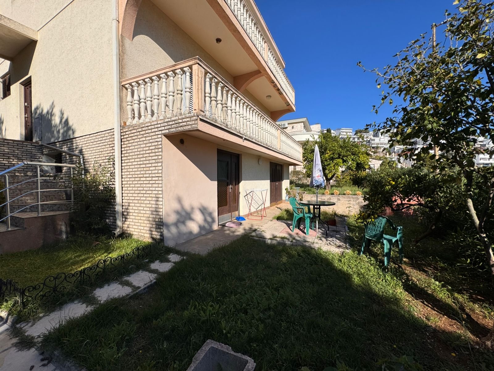 Elegant two-story beige home in Ulcinj with balcony, brick accents, sunny patio, garden&mdash;ideal Montenegro investment by ekosphere doo.