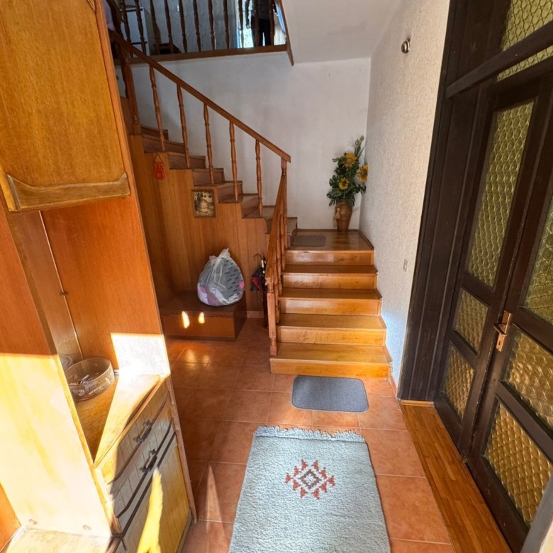 Elegant Ulcinj hallway with wood stairs, tiled floors, glass-paneled door, and premium finishes. Montenegro-listings.me by ekosphere doo.