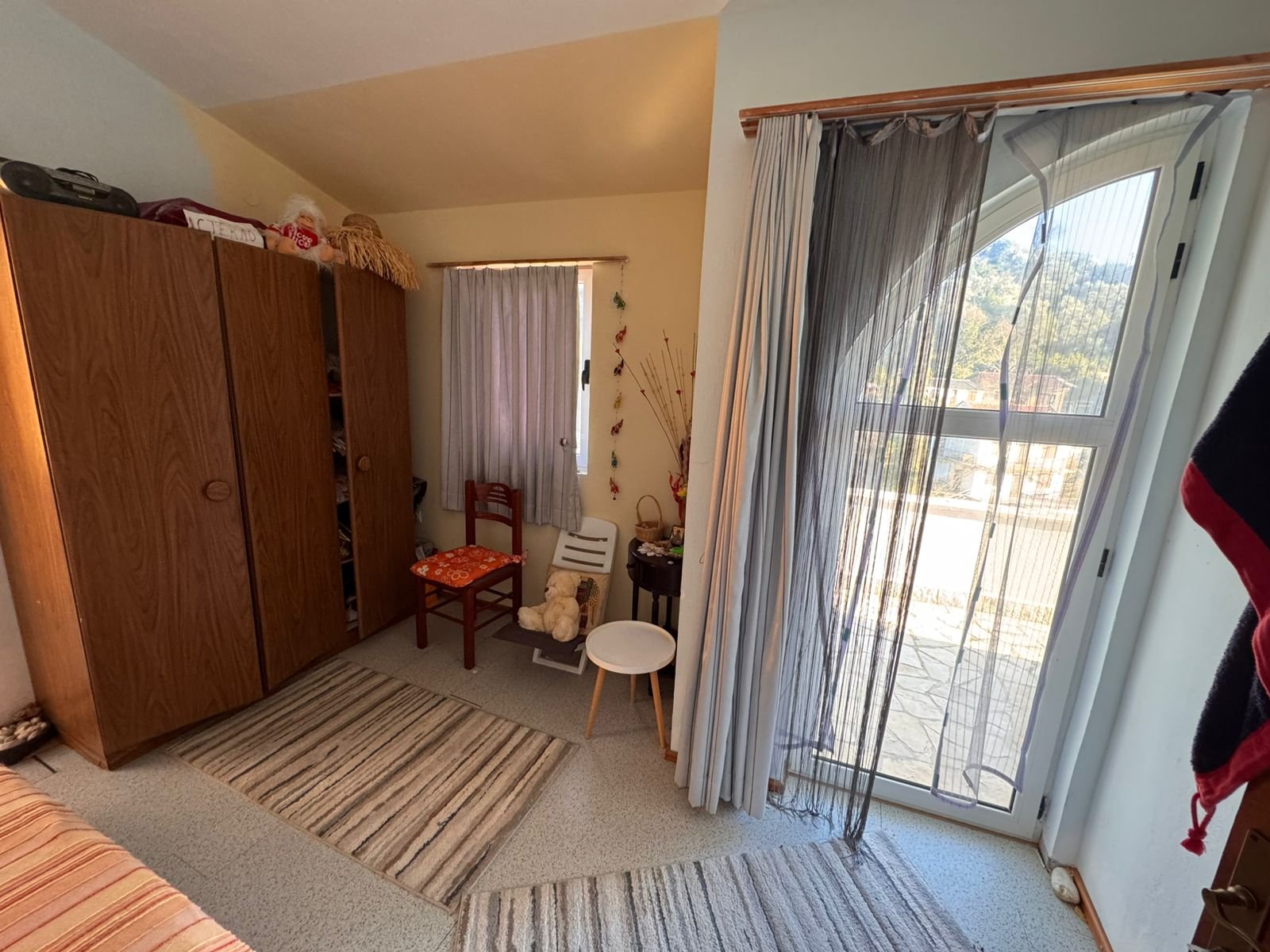 Bright Ulcinj bedroom with wardrobe, cozy balcony access, modern rugs; ideal Montenegro investment listed on immorenta.me.