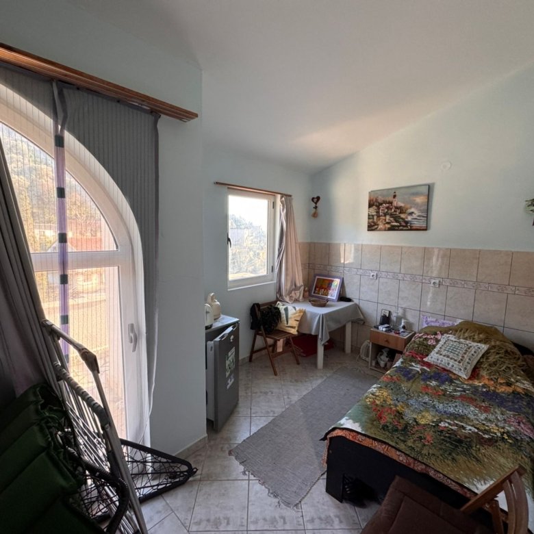 Bright, well-appointed Ulcinj bedroom with single bed, desk, mini fridge, lounge chair. Ideal Montenegro investment via ekosphere doo.