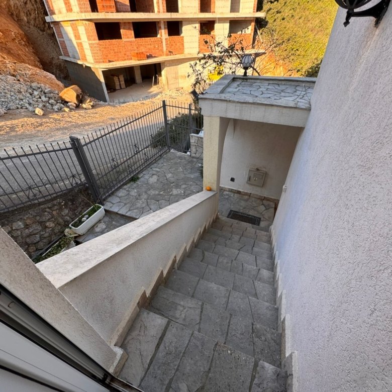 Elegant stone staircase descends to gated entry, overlooking new development potential in Ulcinj. Exclusive on immorenta.me by ekosphere doo.
