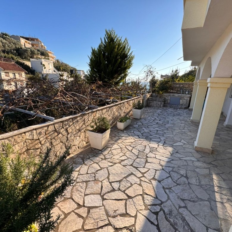 Elegant stone terrace with potted plants, arches, and scenic Ulcinj views. Prime investment via immorenta.me by ekosphere doo.