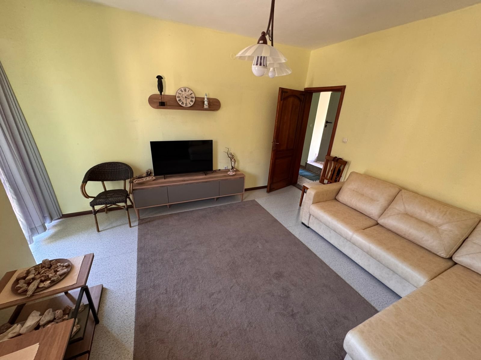 Stylish Ulcinj living room: beige walls, modern tan sectional, TV, decor accents&mdash;prime Montenegro investment at immorenta.me.