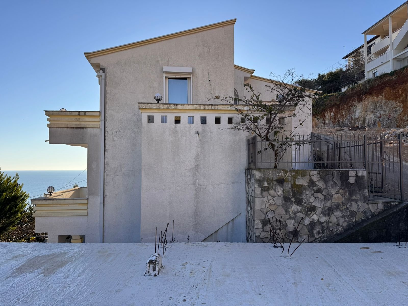 Modern two-story white home with a flat roof, sea views, driveway, and stone wall&mdash;prime Ulcinj investment on immorenta.me.