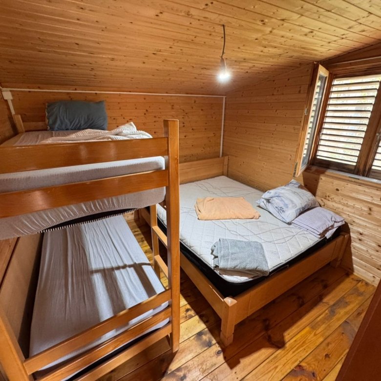 Charming Ulcinj retreat: cozy wood-finished room with bunk and double beds, ideal for Montenegro investment. Eksosphere DOO project.