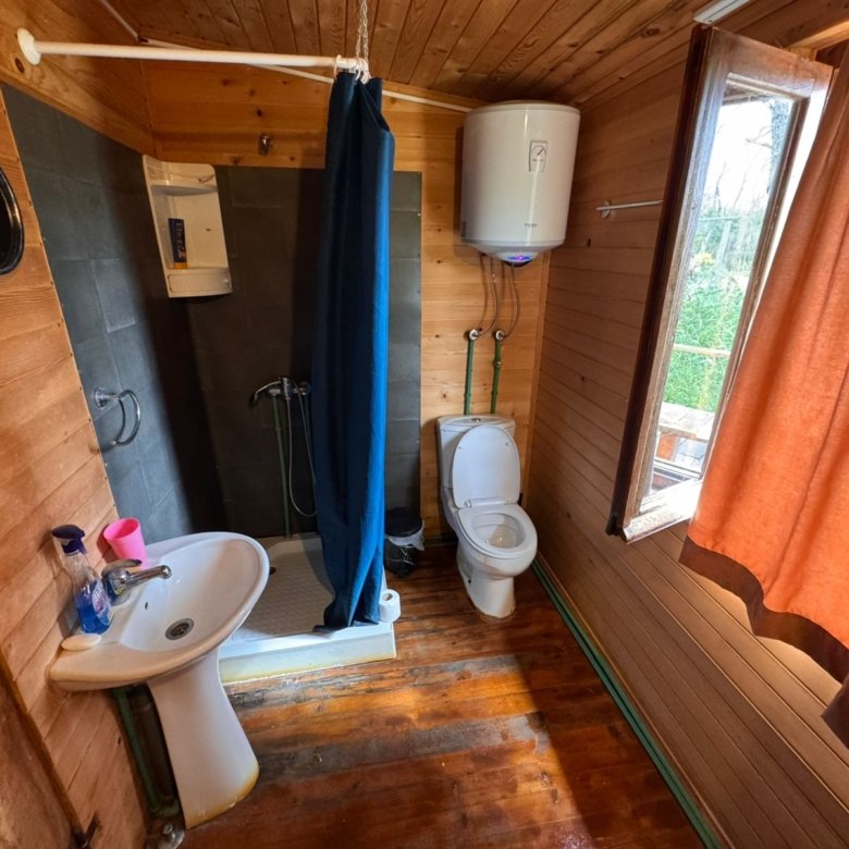 Modern wooden bathroom in Ulcinj with sunlit window, premium shower, quality fixtures. Ideal Montenegro real estate from ekosphere doo.