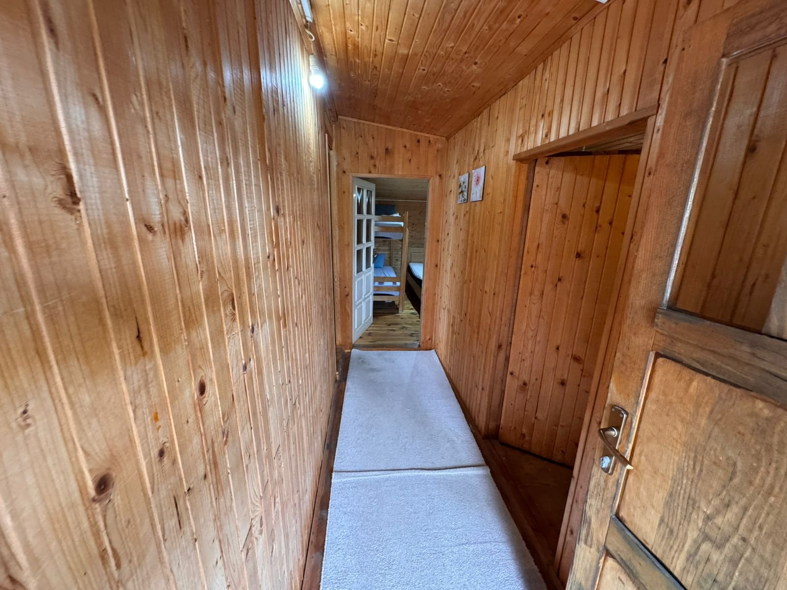 Elegant wooden hallway with premium finishes, white carpets, and cozy bunk beds&mdash;exclusive Ulcinj listing at immorenta.me.