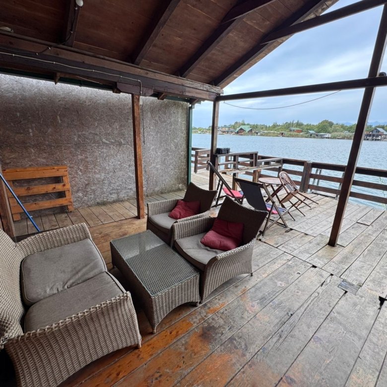 Elegant covered wooden deck with premium wicker seating, glass-top table, and stunning water views in Ulcinj&mdash;exclusive at immorenta.me by ekosphere doo.