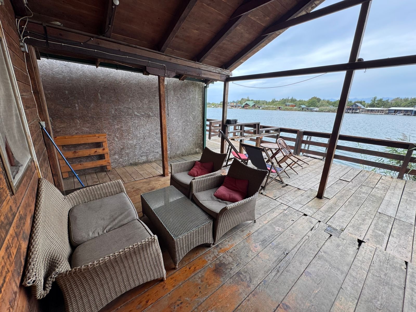 Elegant covered wooden deck with premium wicker seating, glass-top table, and stunning water views in Ulcinj&mdash;exclusive at immorenta.me by ekosphere doo.