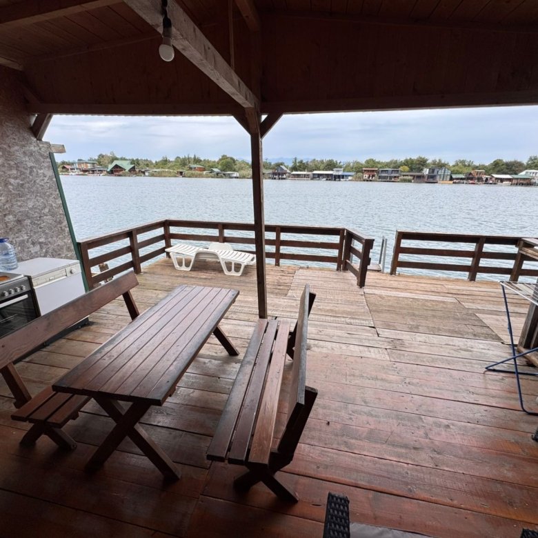 Stunning covered wooden patio with kitchen, sun loungers, and panoramic water views&mdash;prime Ulcinj real estate by ekosphere doo.