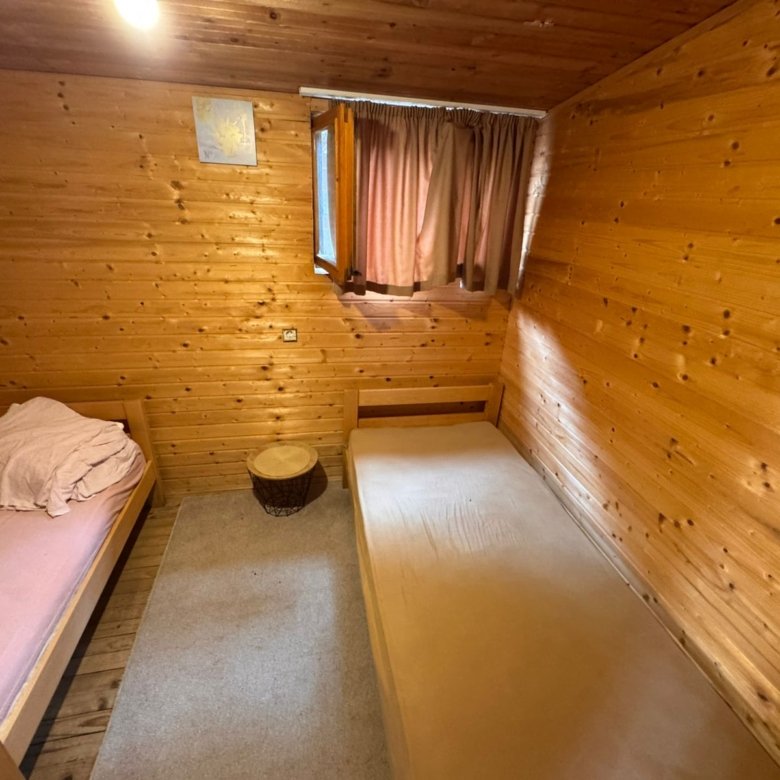 Charming Ulcinj investment: cozy twin room with wood finishes, designer beds, window, and modern lighting. Eksosphere doo listing.