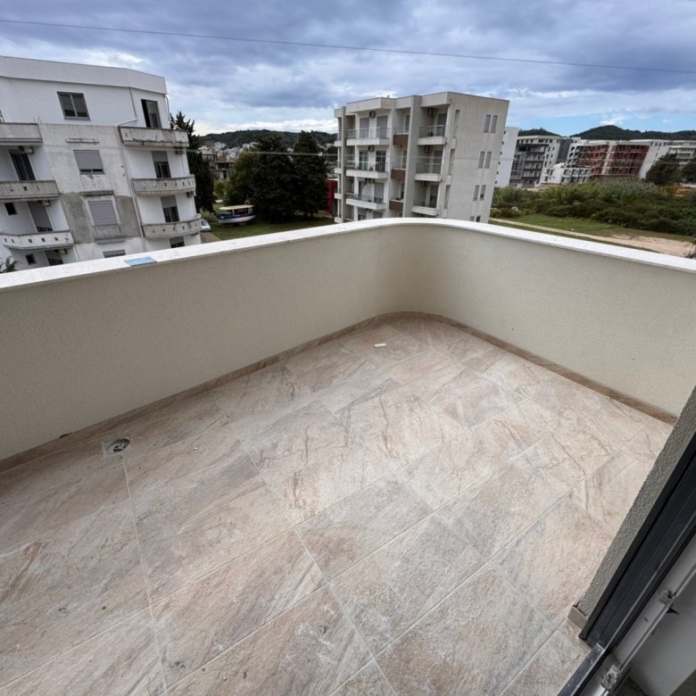 Spacious tiled balcony in Ulcinj with beige floors, cream walls, modern views&mdash;ideal Montenegro investment. View at immorenta.me by ekosphere doo.