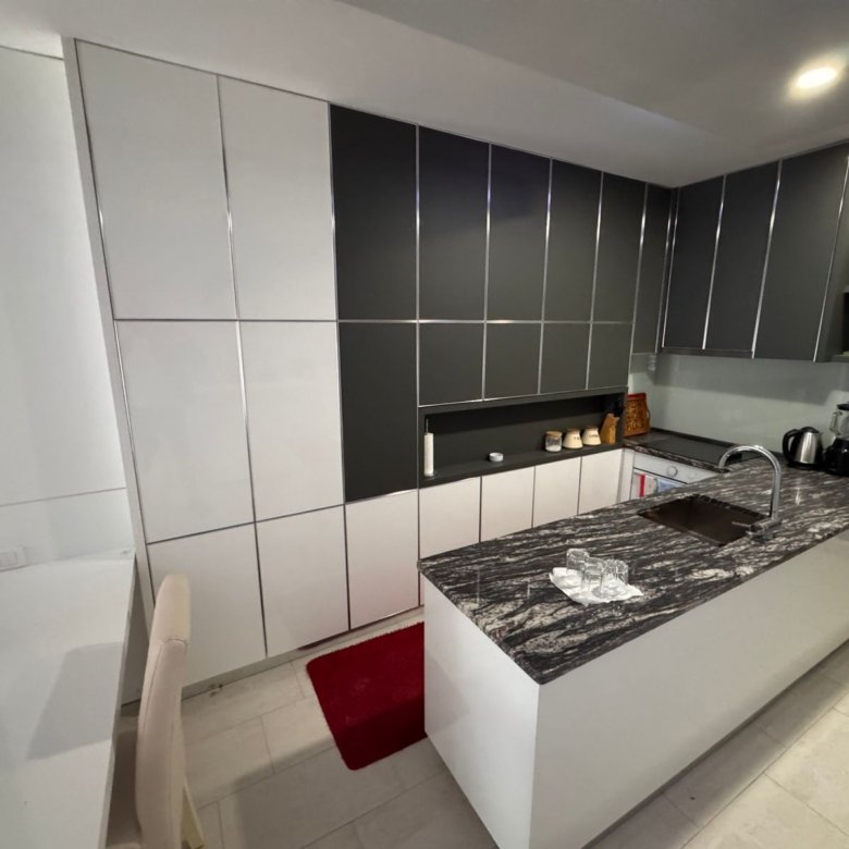 Stunning modern kitchen in Ulcinj, Montenegro&mdash;white & gray cabinetry, marbled island, premium appliances. Invest via immorenta.me.