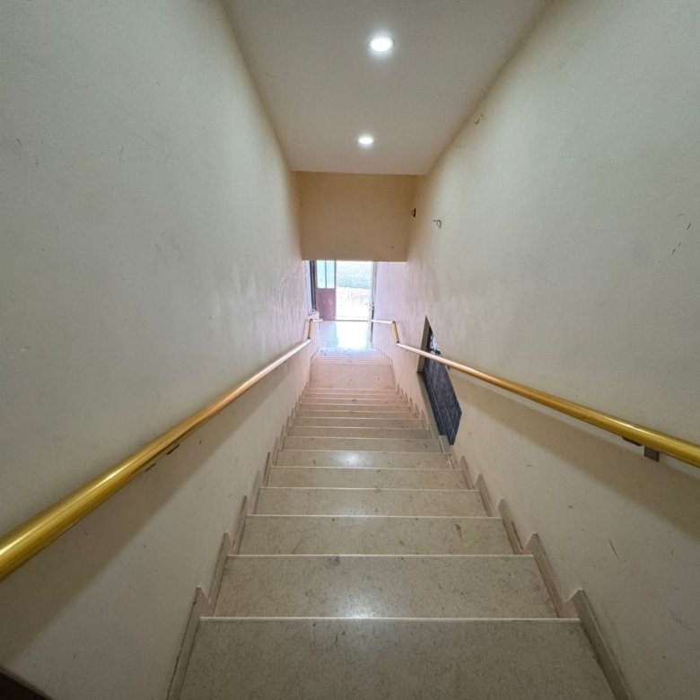 Elegant staircase with beige steps, modern yellow handrails, and bright cream walls&mdash;ideal Ulcinj home investment by immorenta.me.