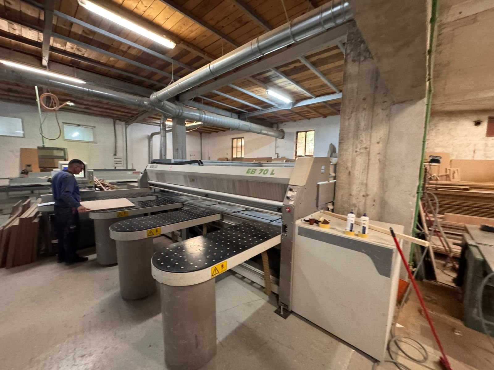 Spacious Ulcinj workshop with robust industrial saw, timber stacks, and wood-beamed ceilings&mdash;prime investment by ekosphere doo.