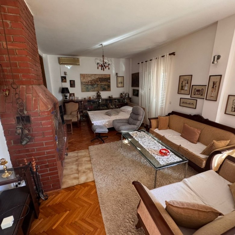 Elegant Ulcinj living room: brick fireplace, wood floors, natural light, ideal Montenegro property&mdash;exclusive at immorenta.me.