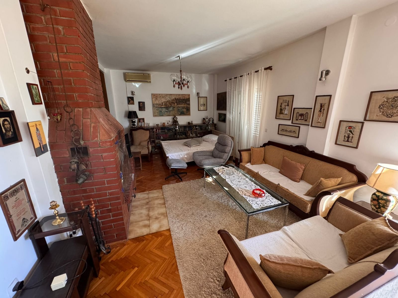 Elegant Ulcinj living room: brick fireplace, wood floors, natural light, ideal Montenegro property&mdash;exclusive at immorenta.me.