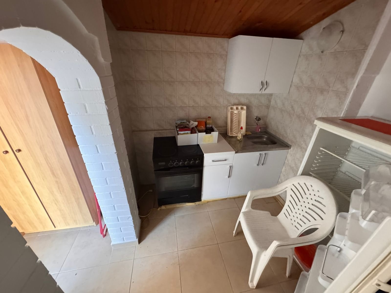 Modern small kitchen in Ulcinj: tiled walls, wood ceiling, archway. Investment-ready, exclusive on immorenta.me by Ekosphere DOO.