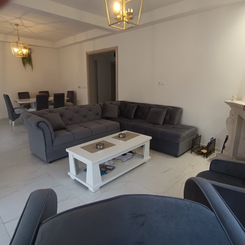 Luxurious Ulcinj apartment: spacious living room with gray sofas, marble floors, dining area. Exclusive at immorenta.me by ekosphere doo.