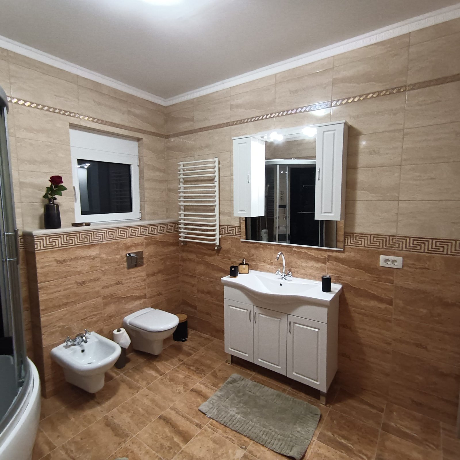 Modern Ulcinj bathroom with beige tiles, premium fixtures, window, and chic vanity&mdash;exclusive listing on immorenta.me by ekosphere doo.