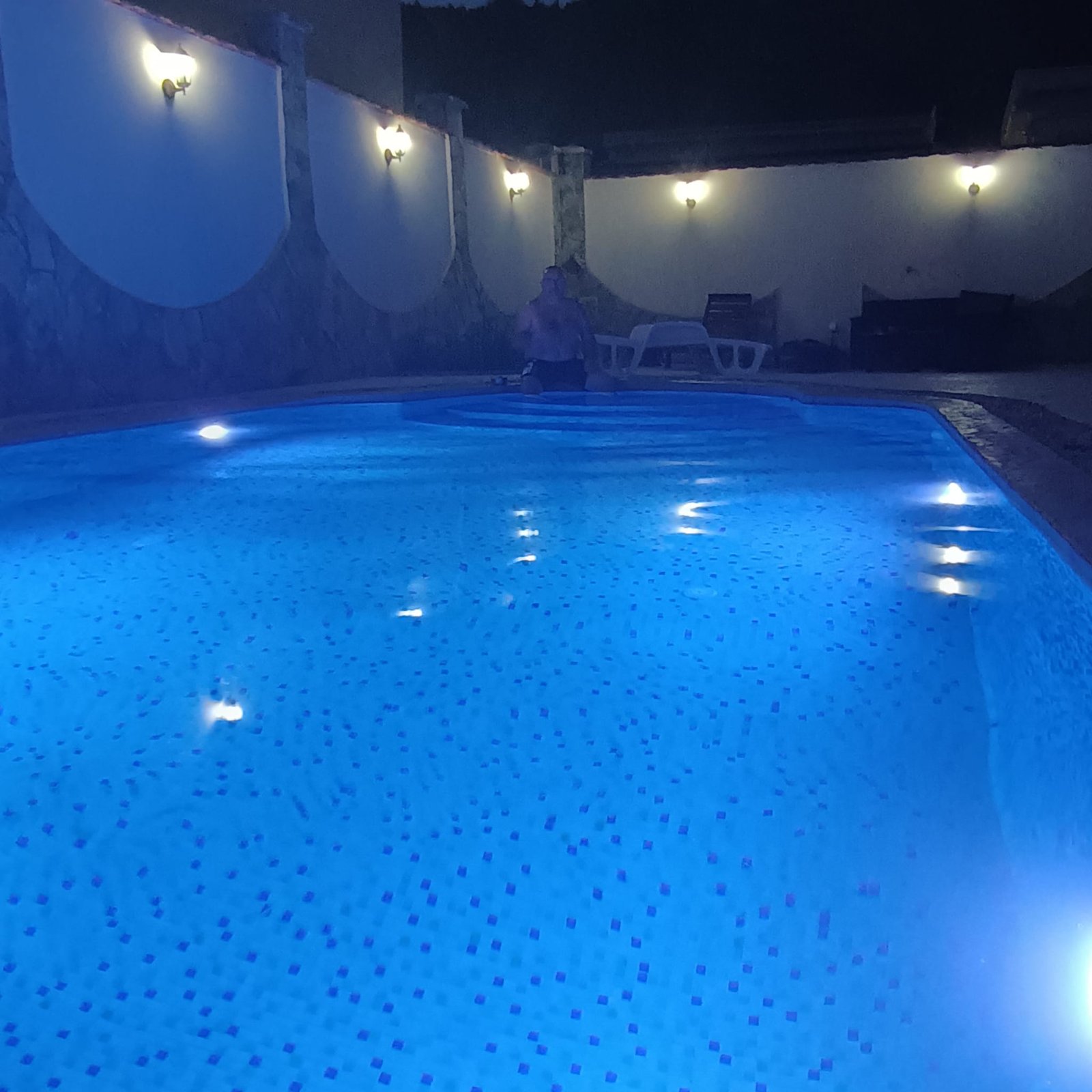 Stunning Ulcinj villa: illuminated pool, elegant stone walls, luxe lounge chair. Invest in Montenegro with immorenta.me.