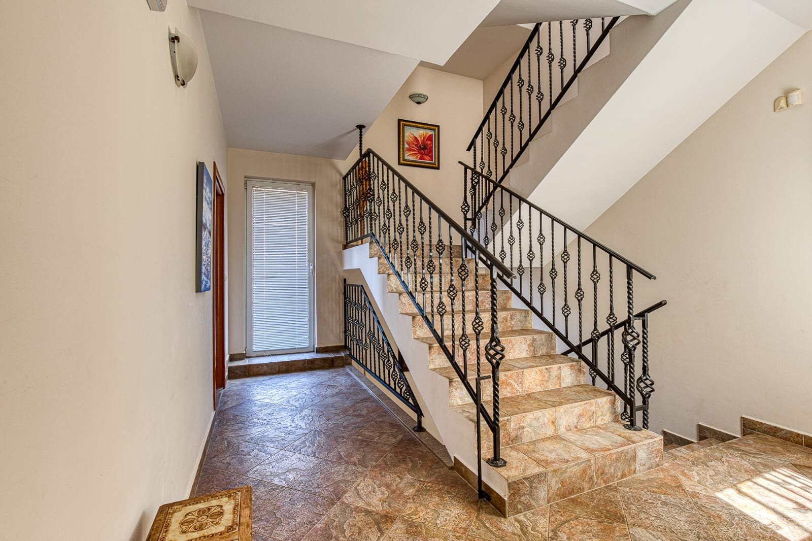 Elegant staircase with brown tiles, black railings, and stylish hallway&mdash;ideal Ulcinj investment! immorenta.me by ekosphere doo.