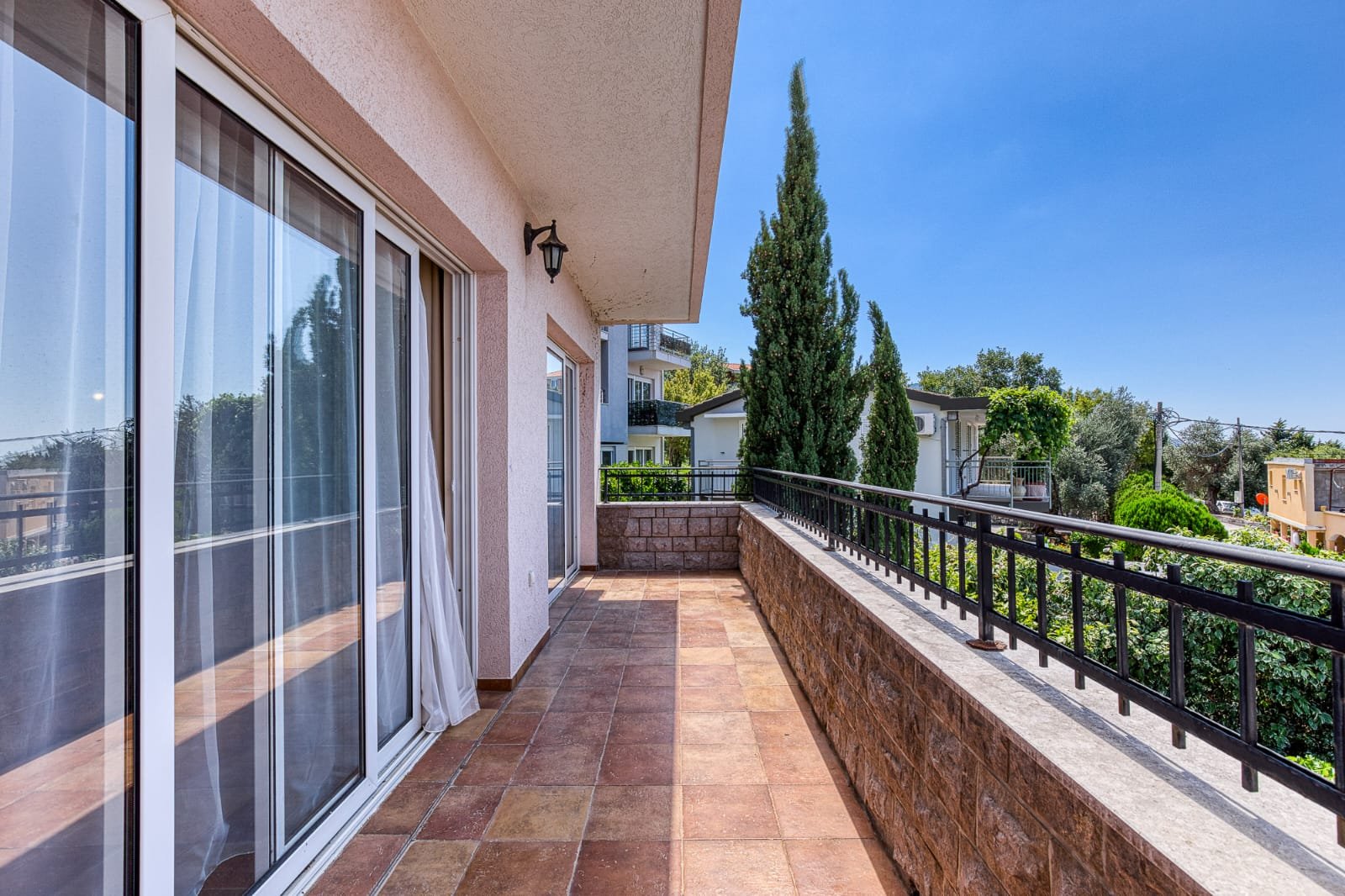 Spacious tiled balcony with metal railing, large glass doors, and scenic Ulcinj views&mdash;prime property via immorenta.me by ekosphere doo.