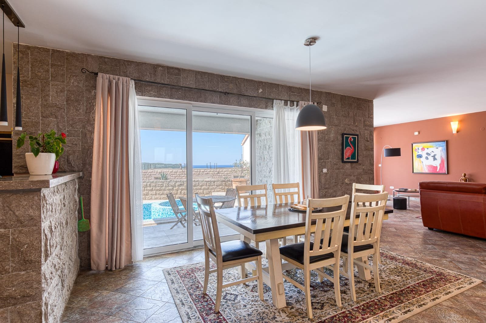 Elegant dining area with stone walls, pool views, and open-plan living&mdash;prime Ulcinj property via immorenta.me by ekosphere doo.