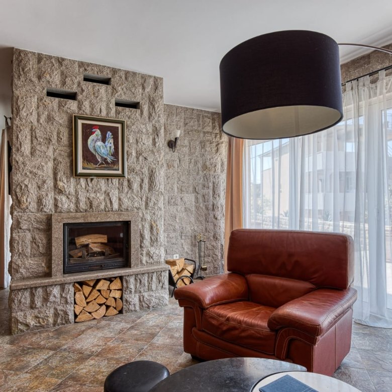 Elegant Ulcinj living room: stone fireplace, large windows, premium finishes. Exclusive on immorenta.me by ekosphere doo.