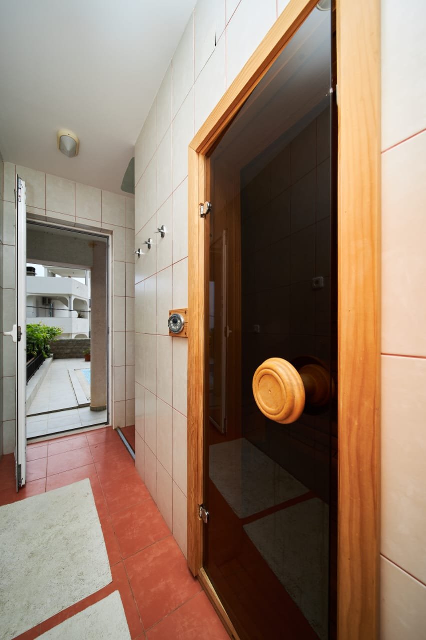 Spacious hallway with elegant red and beige tiles, wooden door, garden patio access&mdash;prime Ulcinj real estate at immorenta.me.