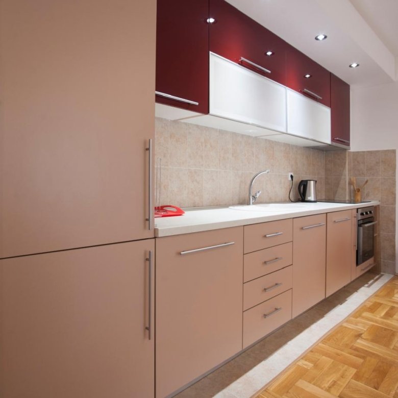 Stylish modern kitchen in Ulcinj, Montenegro: beige and maroon cabinets, parquet floors, tiled backsplash. Listed on immorenta.me by ekosphere doo&mdash;ideal property investment.