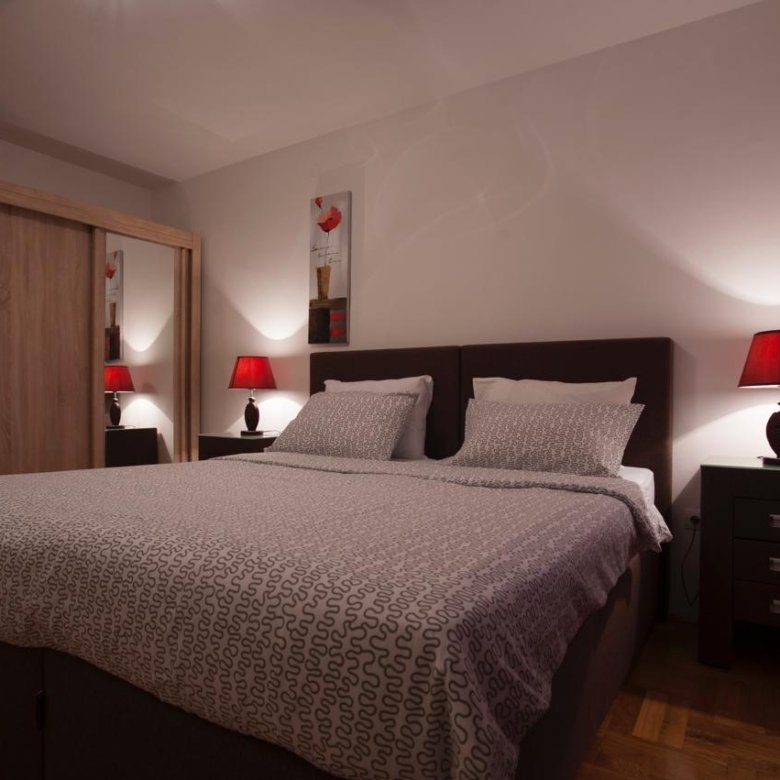 Stylish Ulcinj bedroom with a double bed, mirrored wardrobe, and chic red accents&mdash;exclusive listing on immorenta.me.