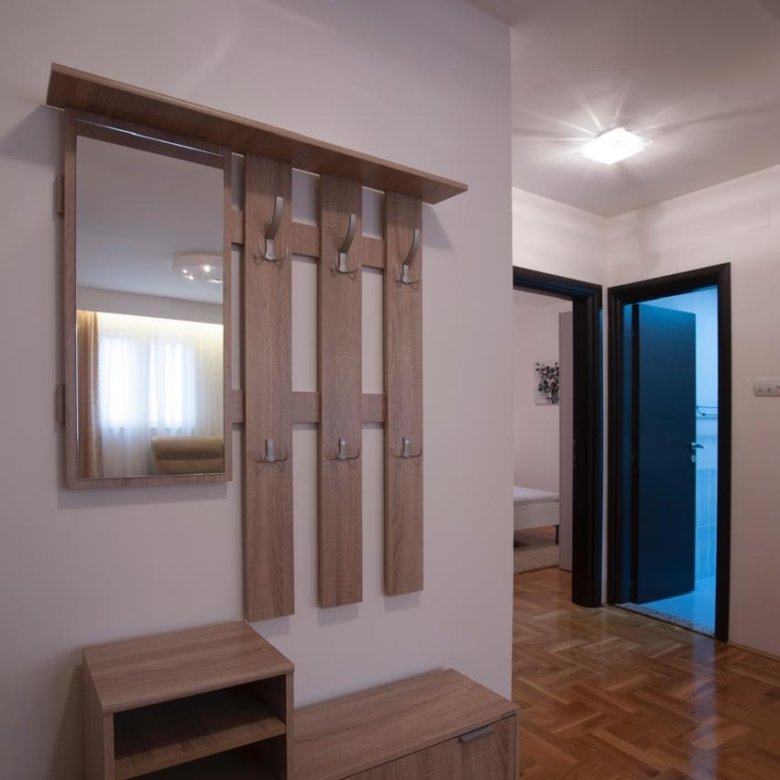 Elegant hallway in Ulcinj property with parquet floors, modern coat rack, ample storage, and access to spacious rooms. Eksosphere DOO project.