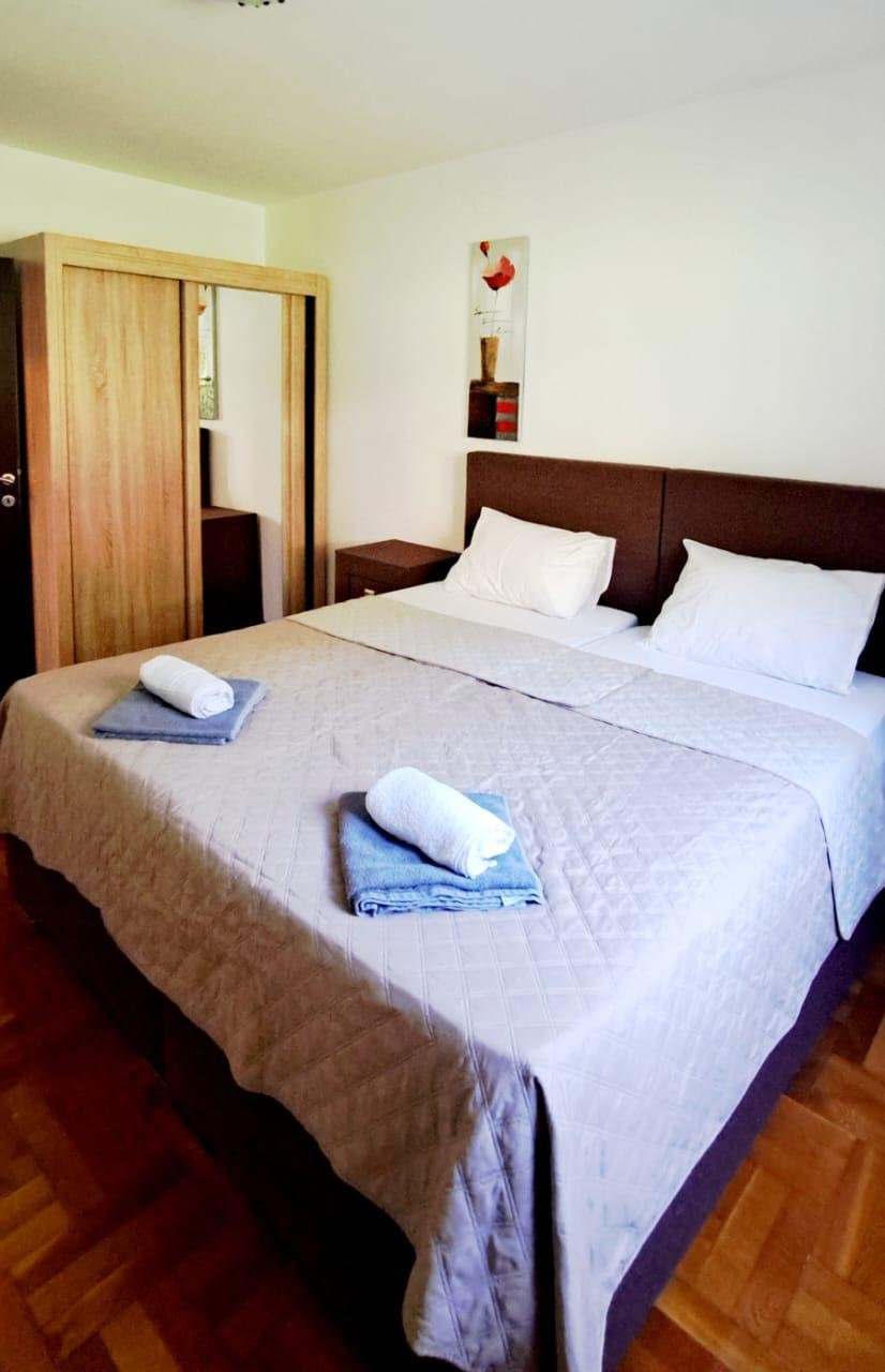 Stylish Ulcinj bedroom with double bed, quality linens, modern wardrobe & decor&mdash;ideal Montenegro investment via immorenta.me.