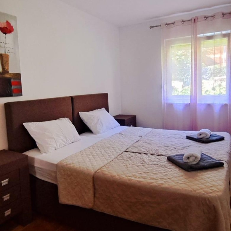 Modern double bedroom in Ulcinj with elegant beige bedding, natural light, and stylish decor&mdash;exclusive at immorenta.me by ekosphere doo.