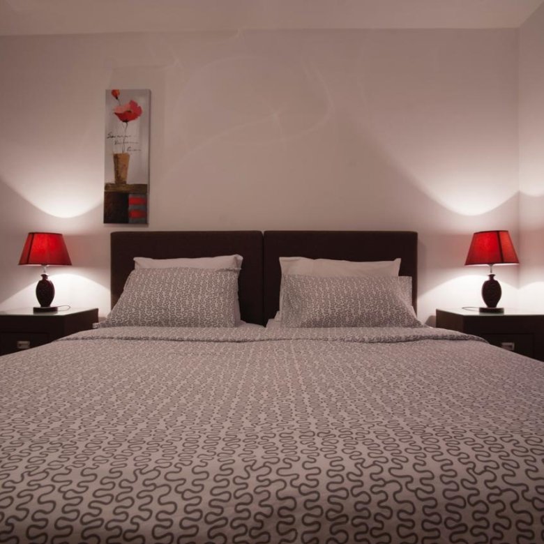 Stylish Ulcinj bedroom with elegant bed, chic bedding, art feature, and ambient lighting&mdash;exclusive on immorenta.me.