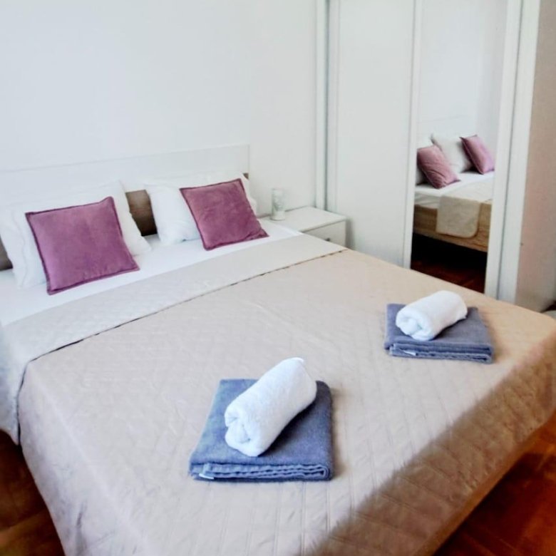 Bright, minimalist Ulcinj bedroom with double bed, luxe linens, mirrored wardrobe&mdash;ideal Montenegro investment at immorenta.me by ekosphere doo.