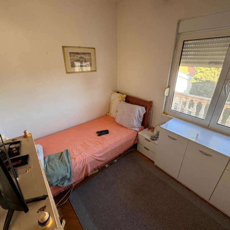 Charming Ulcinj bedroom with single bed, vibrant decor, views, TV, storage & artwork. Ideal Montenegro investment via ekosphere doo.