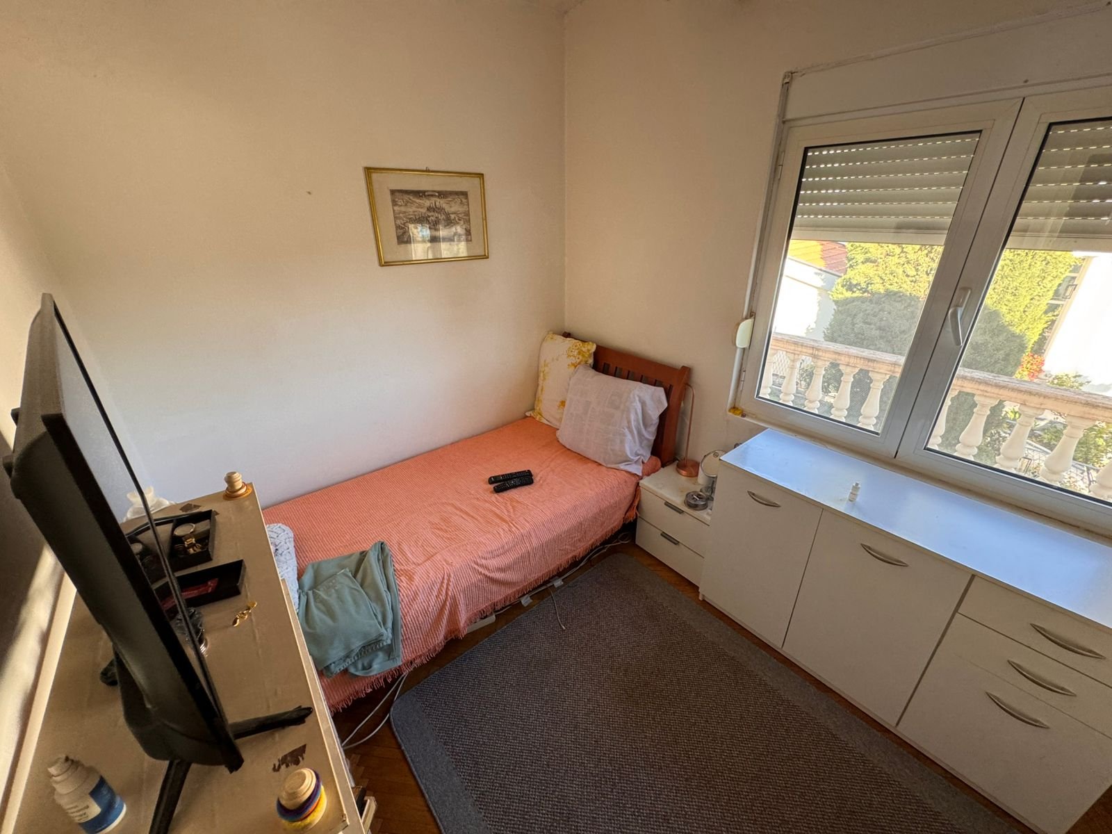 Charming Ulcinj bedroom with single bed, vibrant decor, views, TV, storage & artwork. Ideal Montenegro investment via ekosphere doo.