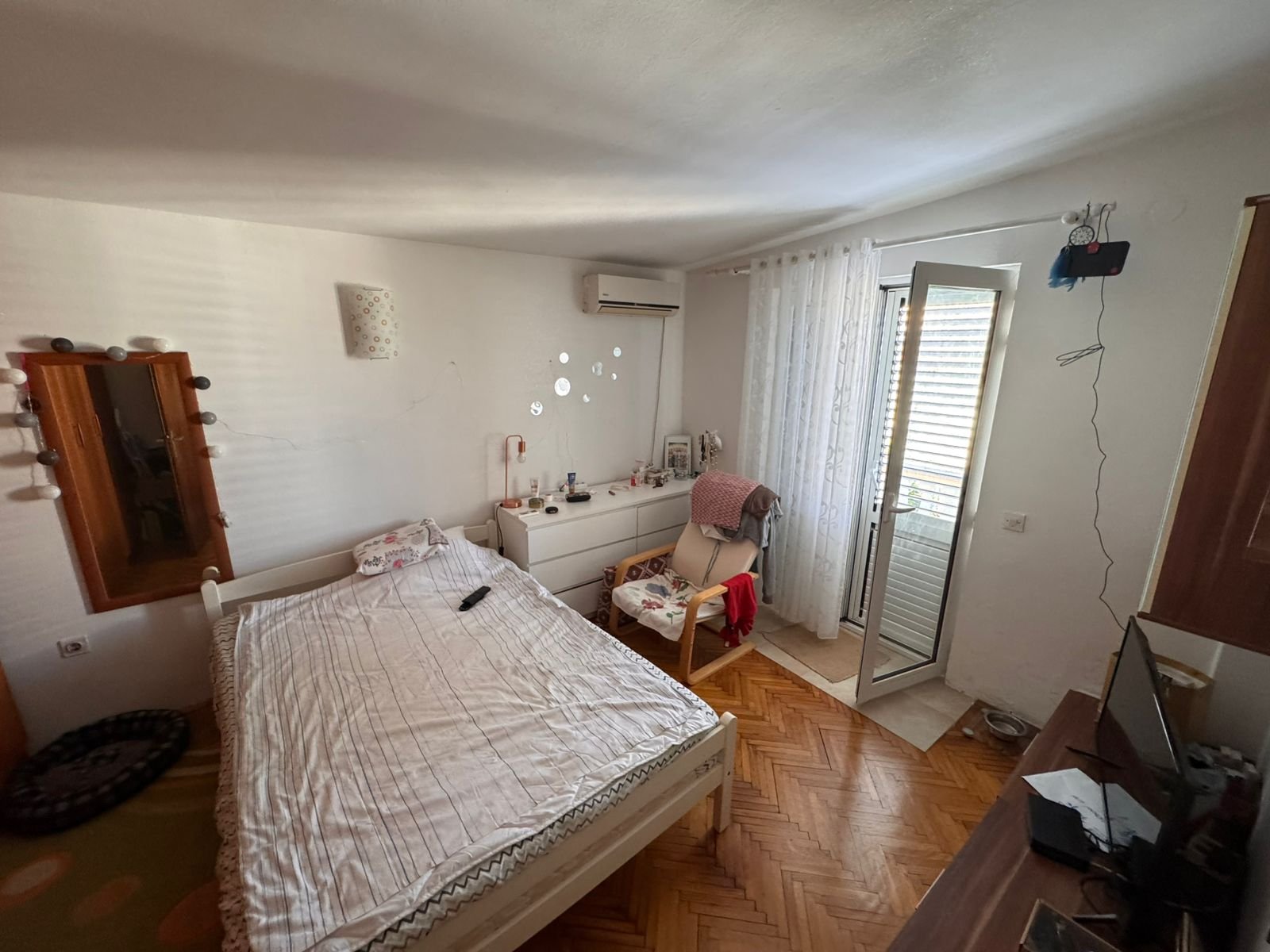 Bright Ulcinj bedroom with balcony access, stylish furnishings, AC, and TV&mdash;ideal Montenegro real estate investment by ekosphere doo.