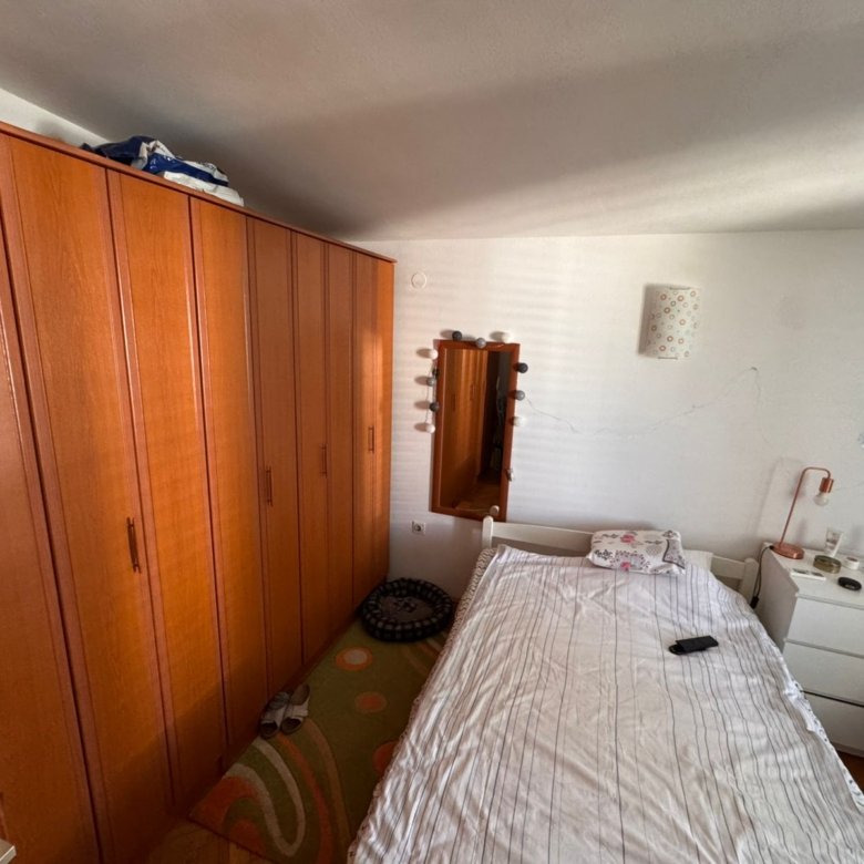 Bright Ulcinj bedroom with wooden wardrobe, single bed, dresser, and mirror&mdash;ideal investment on immorenta.me by ekosphere doo.